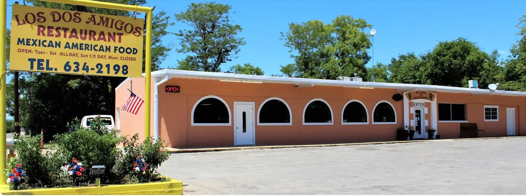 Los Dos Amigos Restaurant exterior with its yellow roadside sign in Center Point, Texas